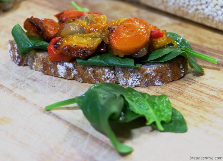 A sandwitch with spinach and roasted veggies